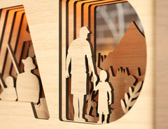 Wooden cutout of a man and child holding hands with additional figures in the background