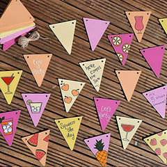 Colorful triangular flags with summer-themed designs on a wooden surface