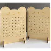 Two wooden pegboards with cat face designs on a plain background