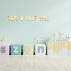 Colorful letter blocks on a light wooden floor with a light blue wall and decorative items.
