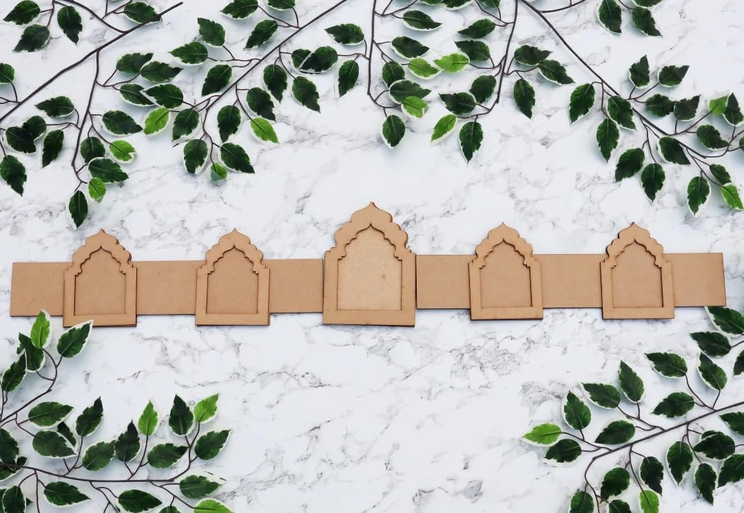 Row of cardboard arches on a marble surface with green leaves