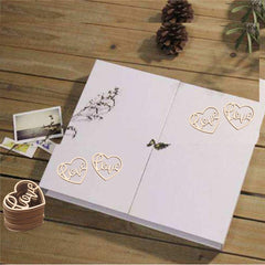 Wooden heart-shaped 'Love' decorations on a white card with a wooden surface background.