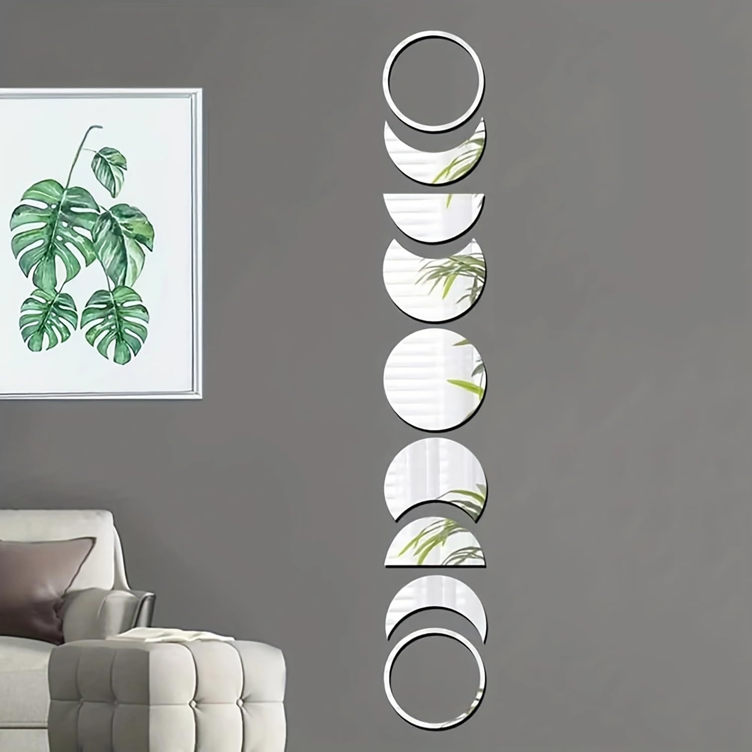 Decorative wall mirrors with leaf patterns on a gray wall above a sofa.