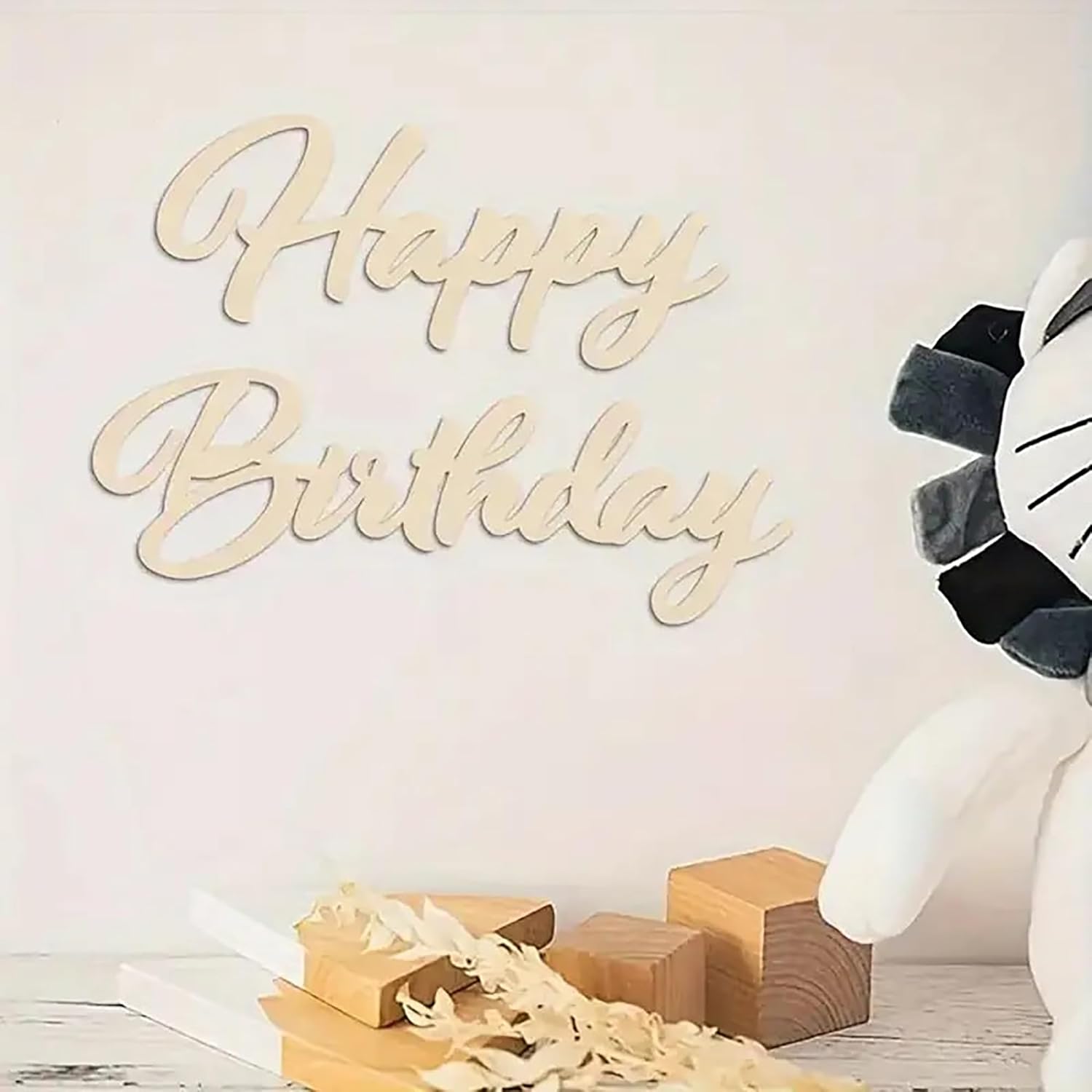 Wooden 'Happy Birthday' sign with decorative elements on a light background