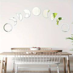 Dining area with a wooden table and chairs, featuring wall-mounted decorative mirrors shaped like phases of the moon.