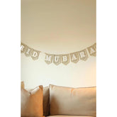 Decorative banner with 'Mubarak' on a wall above pillows