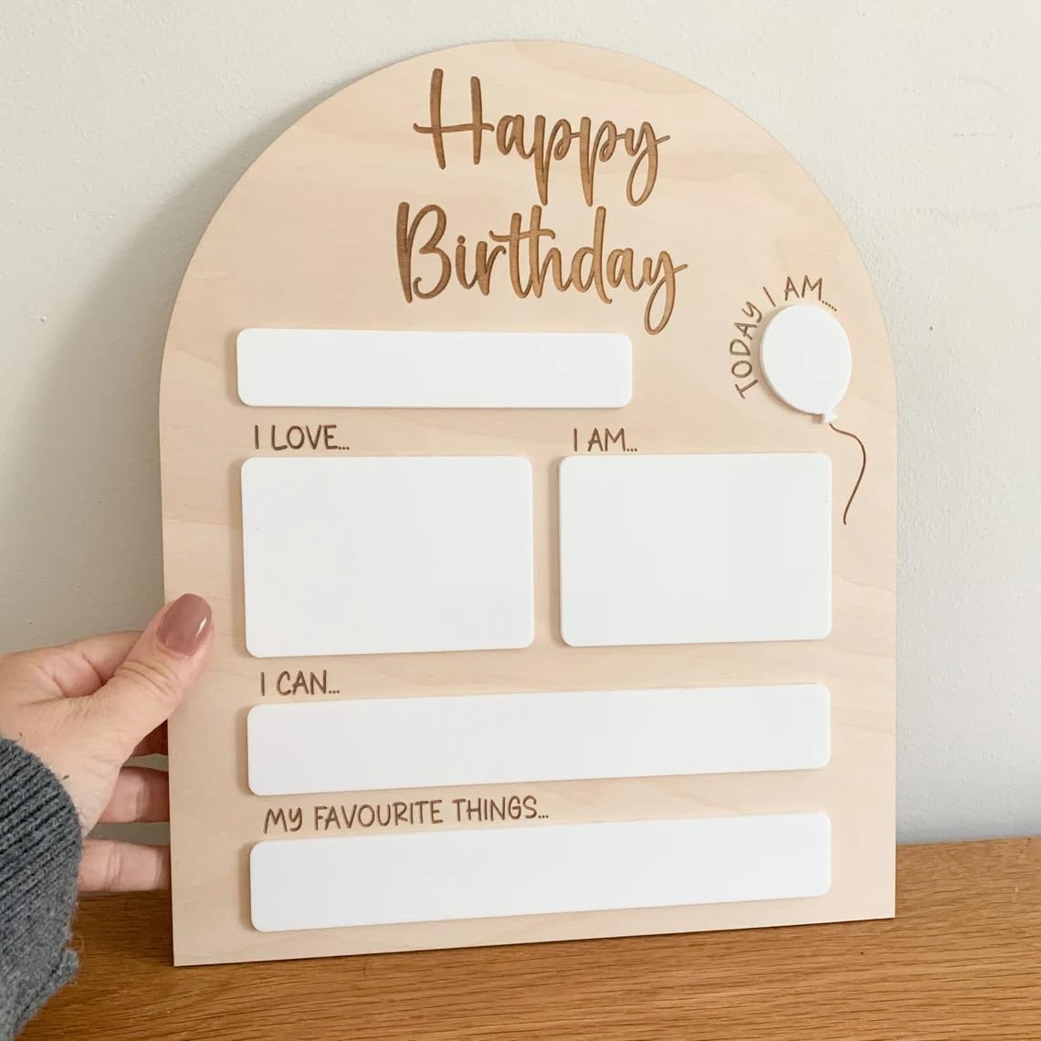 Wooden birthday card with text and space for writing on a wooden surface.