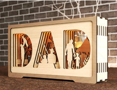 Wooden decorative item with 'DAD' letters against a brick wall background