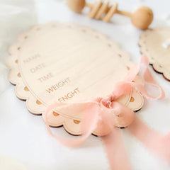 Baby weight chart with pink ribbon on a white background