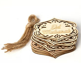 Stack of wooden 'Eid Mubarak' cards with a tassel on a white background