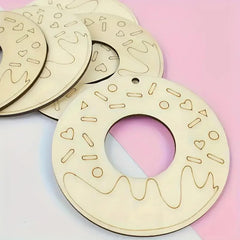Wooden donut-shaped ornament with decorative patterns on a pink and white background