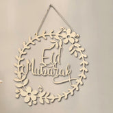 Decorative wall hanging with 'Eid Mubarak' text on a beige background