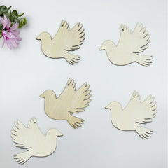 Five wooden dove shapes on a light background with a pink flower.