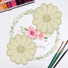 Floral design with flowers and leaves on a white background, surrounded by watercolor paints and brushes.