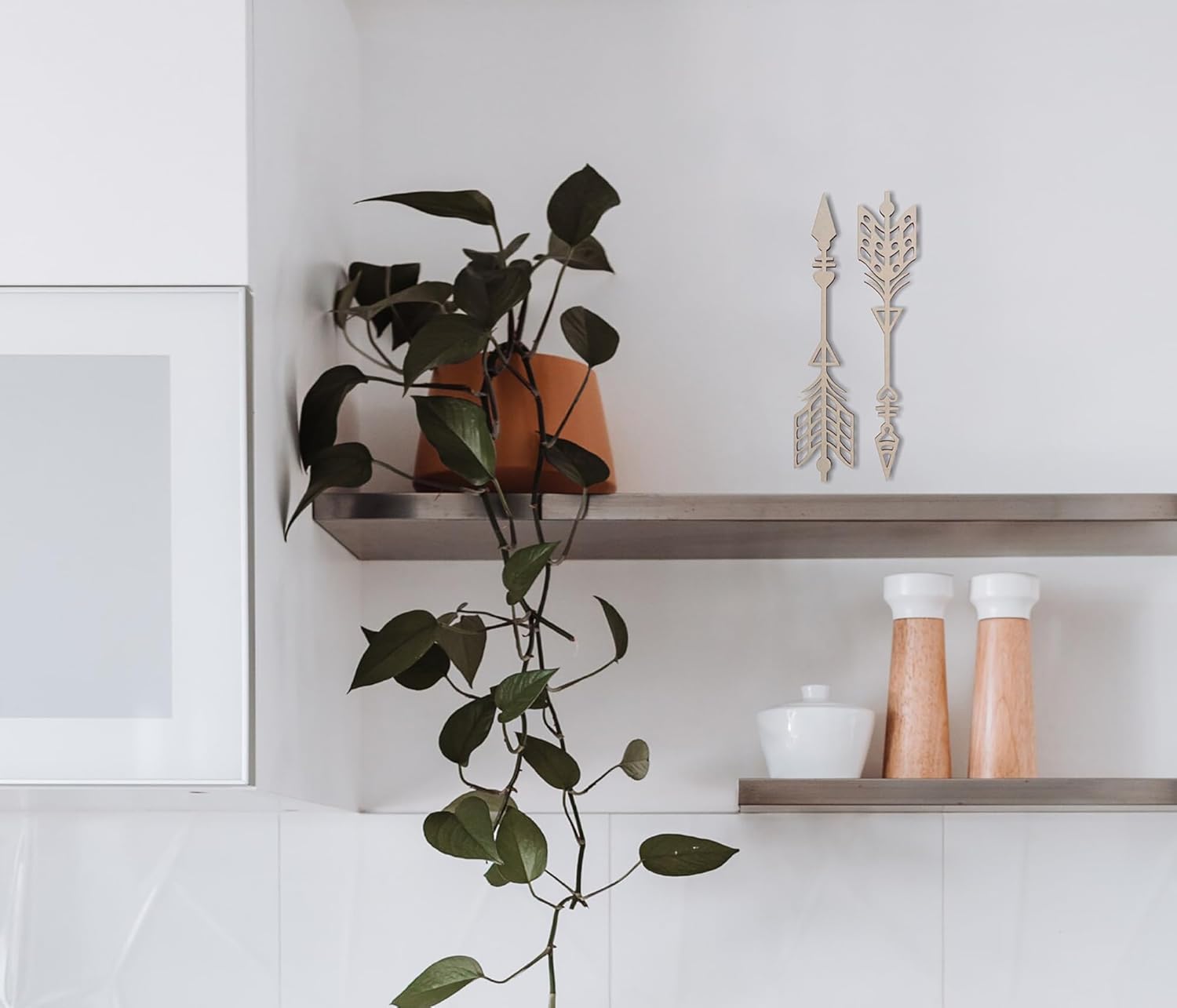 Shelving unit with decorative items including a plant, arrows, and jars.