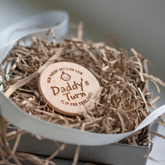 Wooden 'Daddy's Turn' coin in a decorative box with straw-like material