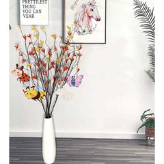 Decorative vase with branches and small animals in a room setting.