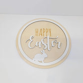 Round decorative sign with 'Happy Easter' text and a rabbit silhouette on a white background