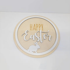 Round decorative sign with 'Happy Easter' text and a rabbit silhouette on a white background