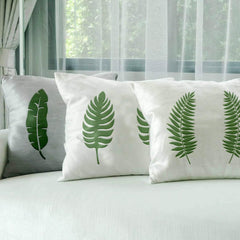 Decorative pillows with leaf patterns on a bed