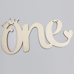 Wooden decorative sign with 'one' and a crown on a gray background