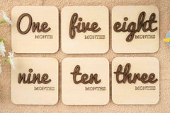 Six wooden cards with text indicating months on a textured surface.
