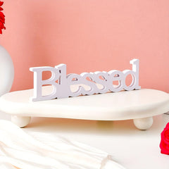 White decorative word 'Blessed' on a pink background