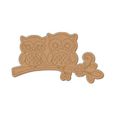 Cardboard cutout of two owls on a branch with decorative elements on a white background