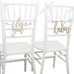 Two white chairs with gold 'I love you' and 'know' signs on a white background