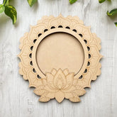 Wooden lotus flower decorative item on a light wooden surface with green leaves.