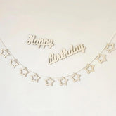 Wooden 'Happy Birthday' banner with star shapes on a white background