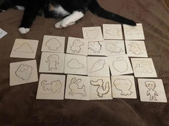 Set of wooden stamps with various shapes and designs on a brown surface, with a cat partially visible.