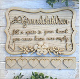 Wooden decorative sign with engraved text and floral design on a wooden background