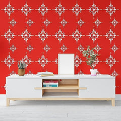 White entertainment console with wooden shelf against a red wall with white geometric pattern