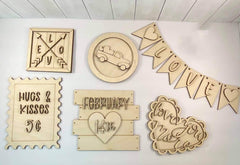 Collection of wooden decorative signs with various designs on a white surface.