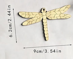 Wooden dragonfly ornament with measurements on a white background