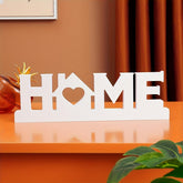 Decorative sign with 'HOME' on a wooden surface
