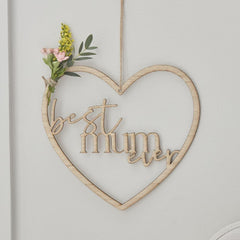 Heart-shaped wooden sign with 'best mum ever' text and floral decoration on a light background