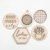 Set of wooden decor items with engraved phrases and patterns on a white background