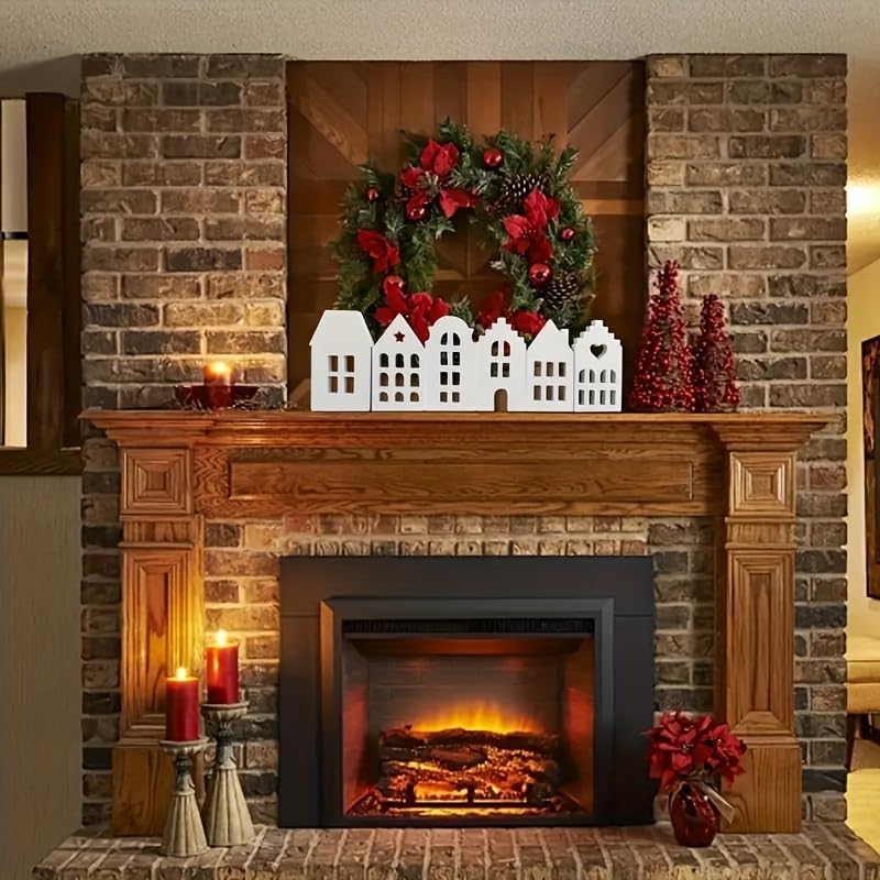 Decorated fireplace with a wreath, candles, and small houses on a brick wall.