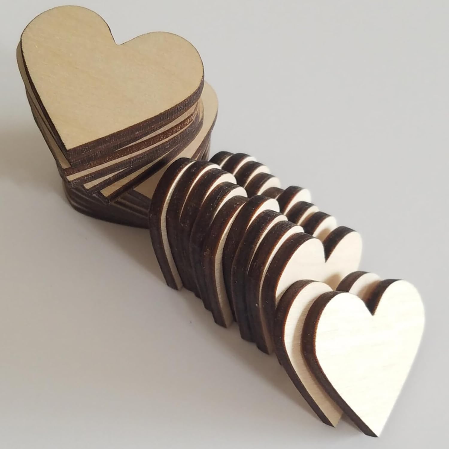 Stack of wooden heart-shaped objects on a light gray background