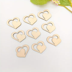 Gold heart-shaped objects on a white surface with green leaves in the background