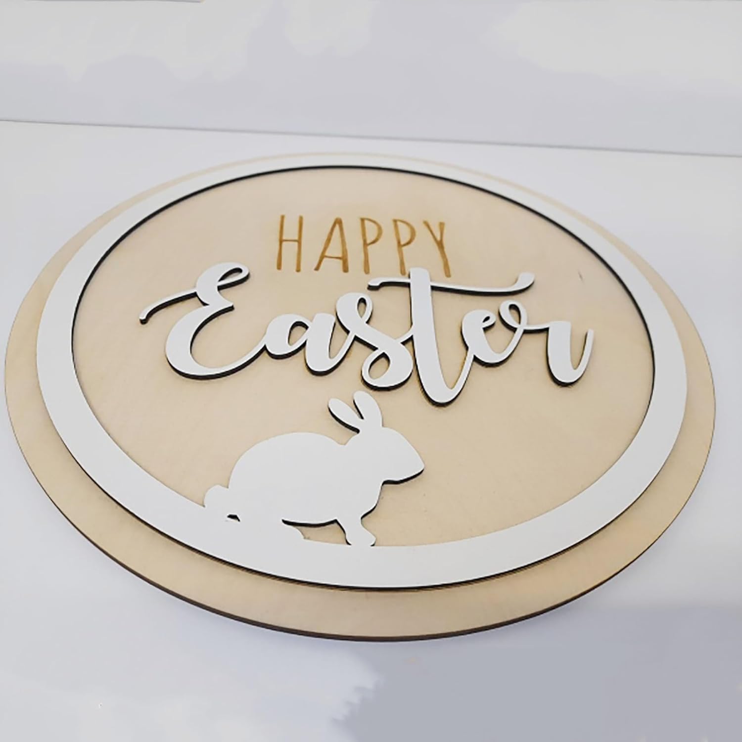 Decorative sign with 'Happy Easter' text and a rabbit silhouette on a beige background.