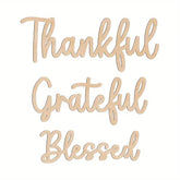 Wooden cutout letters spelling 'Thankful', 'Grateful', and 'Blessed' on a white background