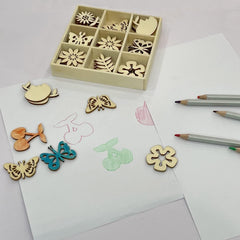 Wooden stamps with floral and butterfly designs on a white surface with colored pencils.