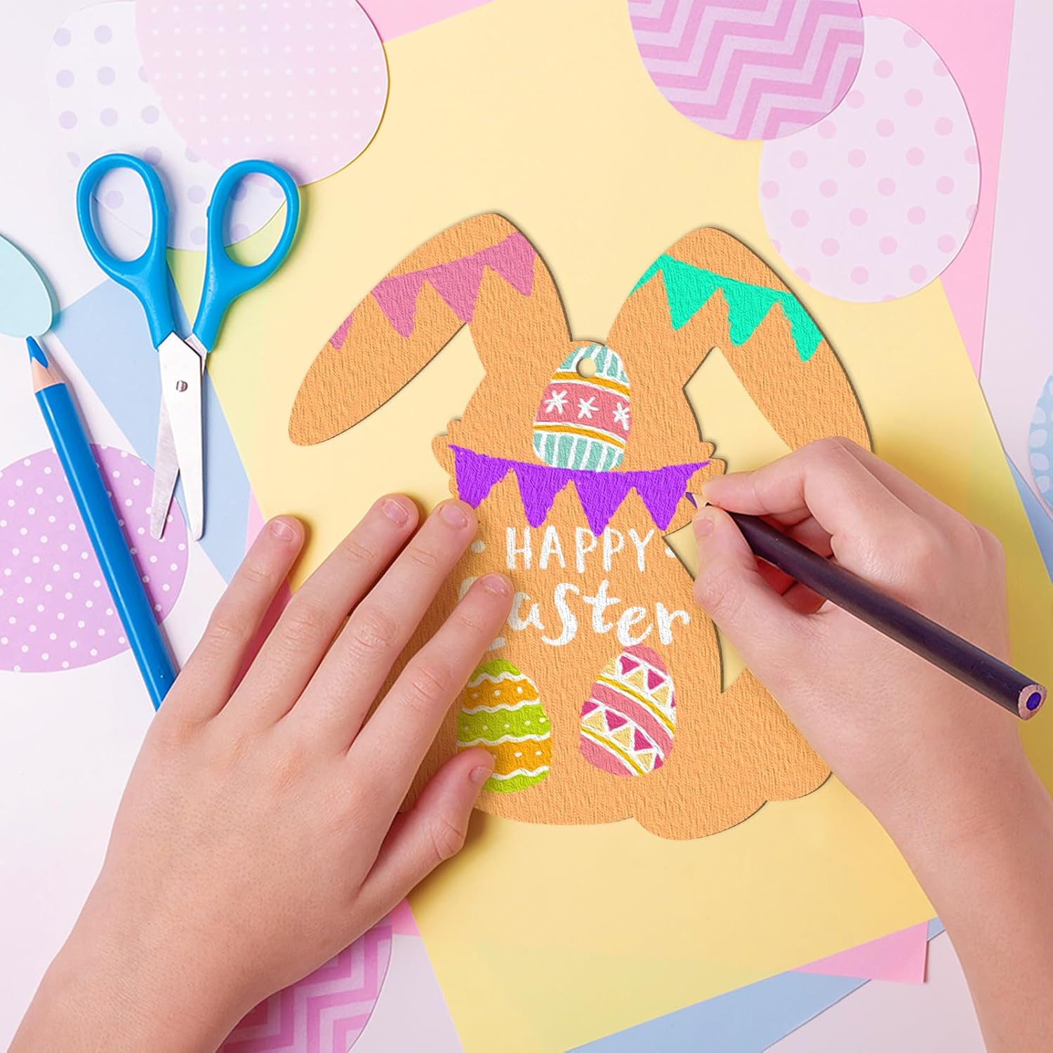 Child's hands coloring a Easter craft with scissors and markers on a colorful background