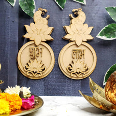 Pair of gold earrings with decorative elements on a blue fabric background.