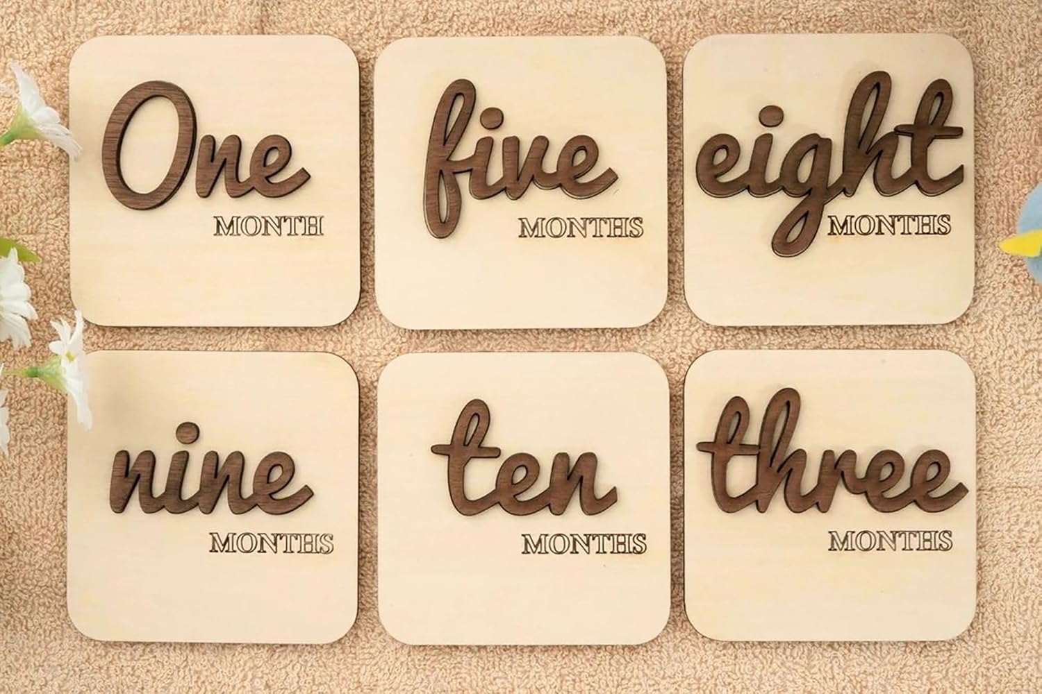 Six wooden cards with text indicating months on a textured surface.