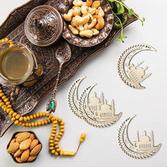 Decorative items including a tray with nuts, a glass of tea, a rosary, and decorative crescent moon and star pieces on a white background.