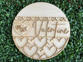 Wooden decorative item with 'Be My Valentine' text on a green leaf background